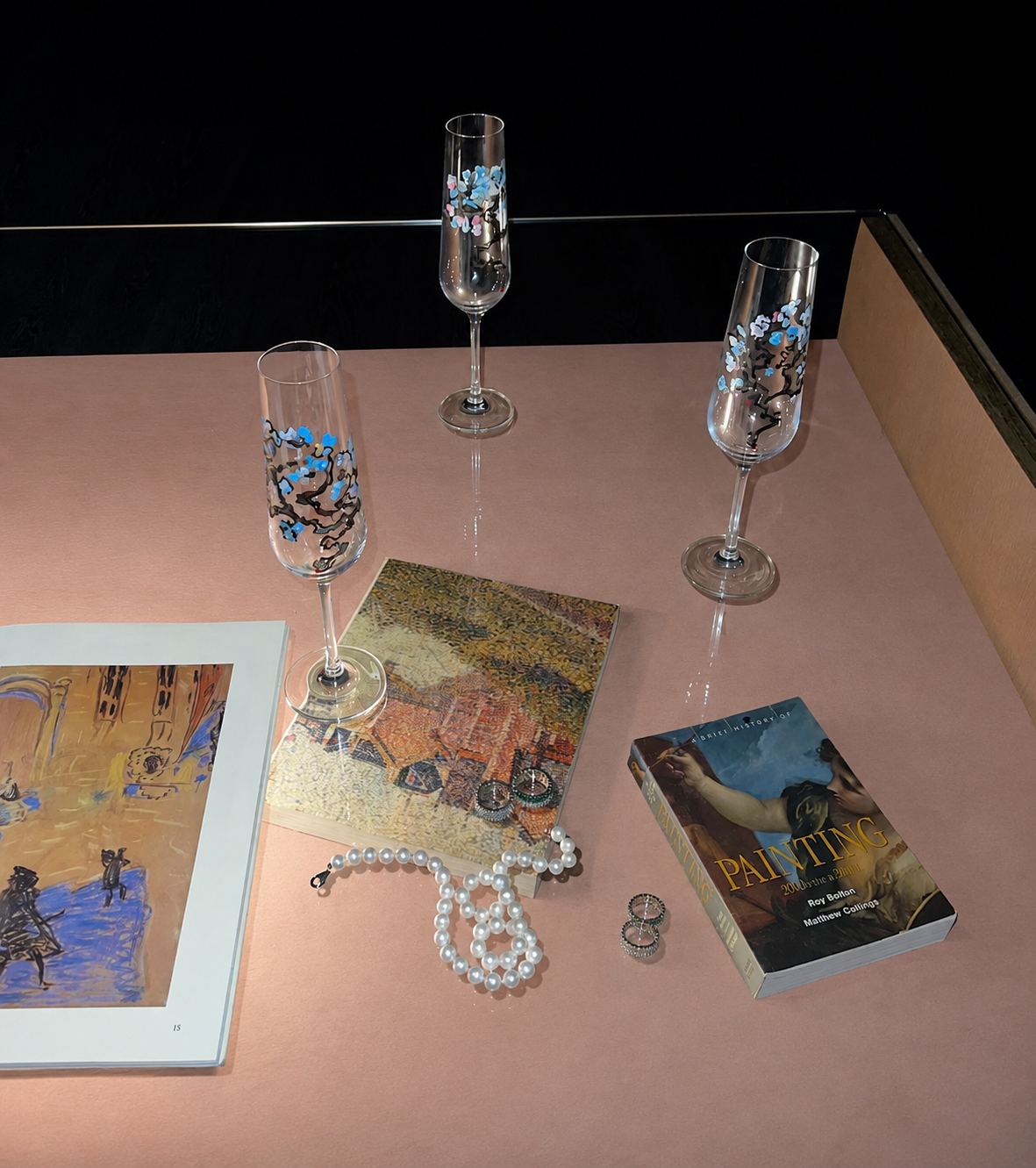 Inside the Passionflowwer studio — art books, pearls and painted glasses on a pink table